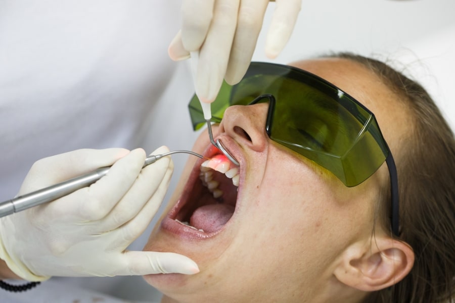 Dentist performing laser treatment on a patient’s gums